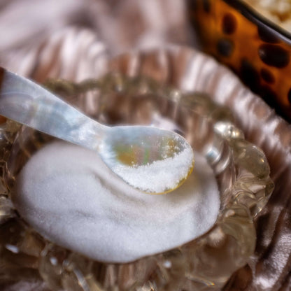 One mother of pearl caviar spoon dipping into spices.