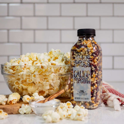 Calico popcorn kernel mix by Petersen Family Farm. 16oz Plastic bottle on counter with popcorn