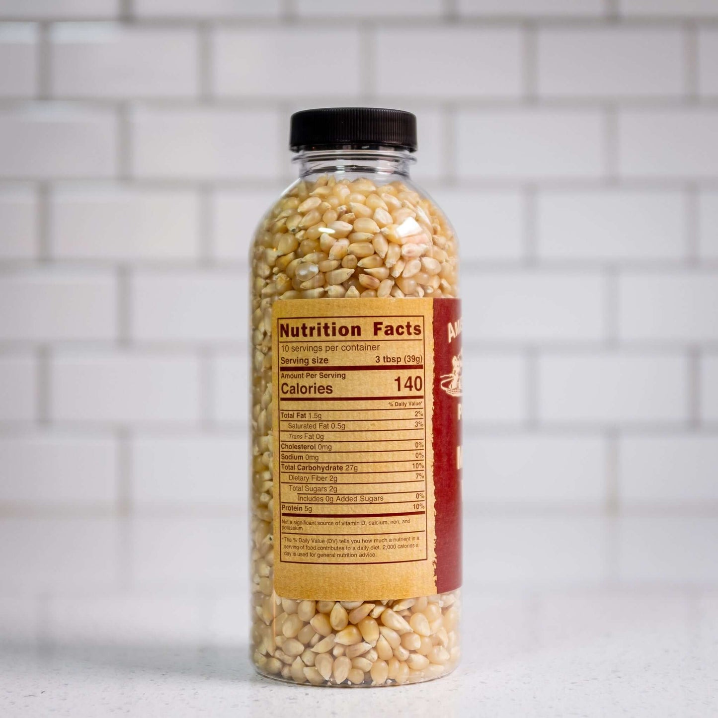 Medium white hulless popcorn kernels by Amish Country Popcorn. Side of 14oz plastic bottle