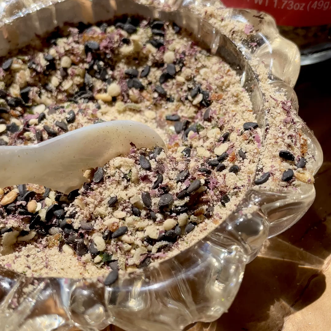 Video of an extreme close up of furikake spice being mixed around by a caviar spoon.